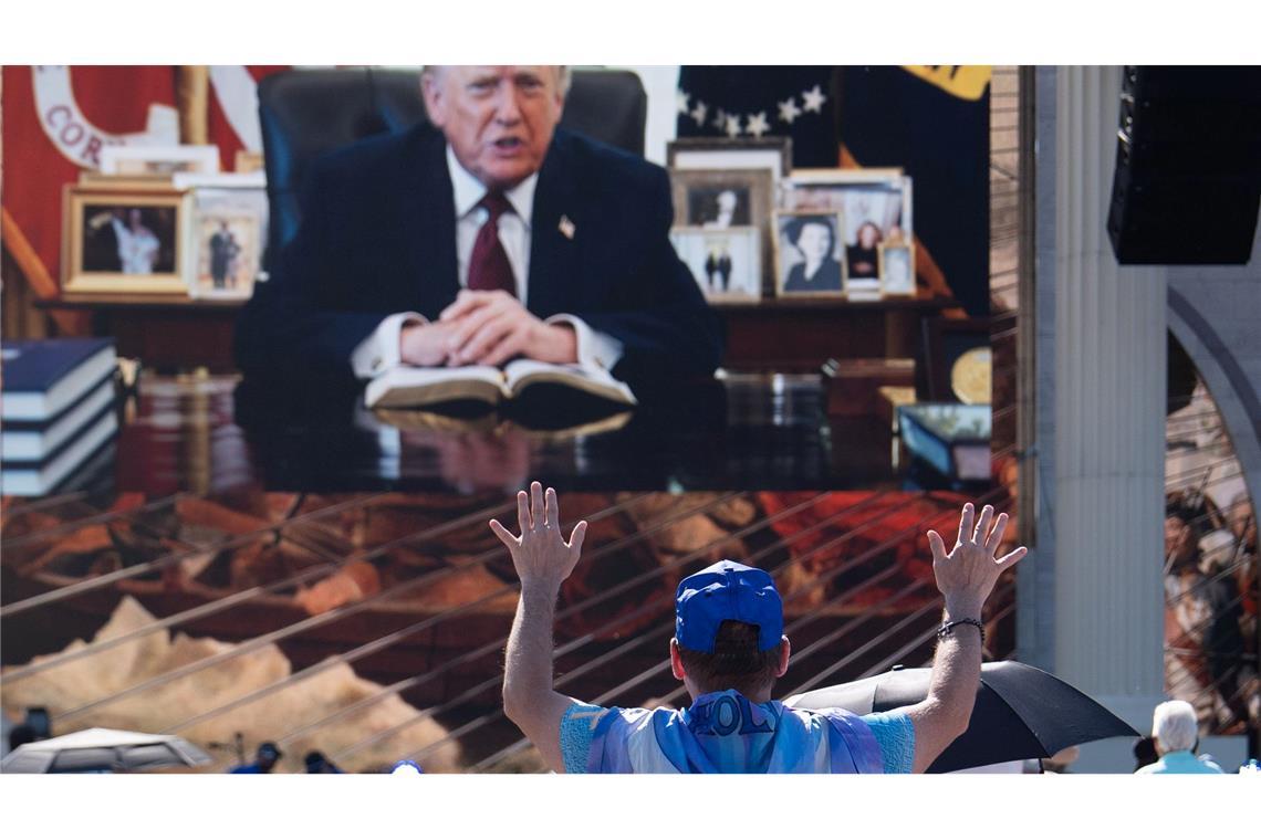 Eine Person betet, während eine aufgezeichnete Videobotschaft von US-Präsident Donald Trump abgespielt wird.