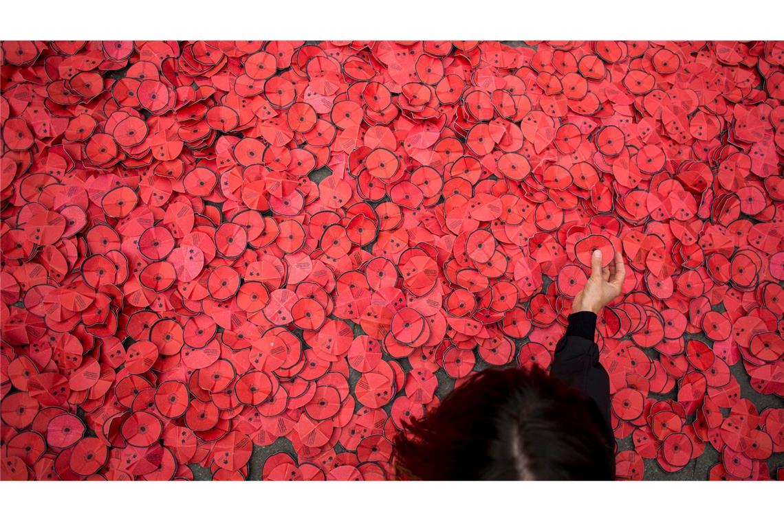 Bilder des Tages Eine Person hebt eine Papiermohnblume auf, die während einer Kundgebung gegen den Gaza-Krieg vor dem spanischen Außenministerium in Madrid auf dem Boden liegt.