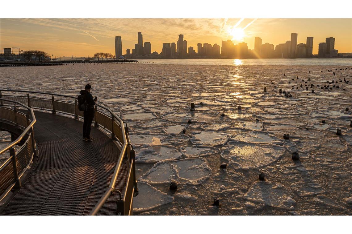 Bilder des Tages Eine Person macht ein Foto vom eisbedeckten Hudson River in New York.