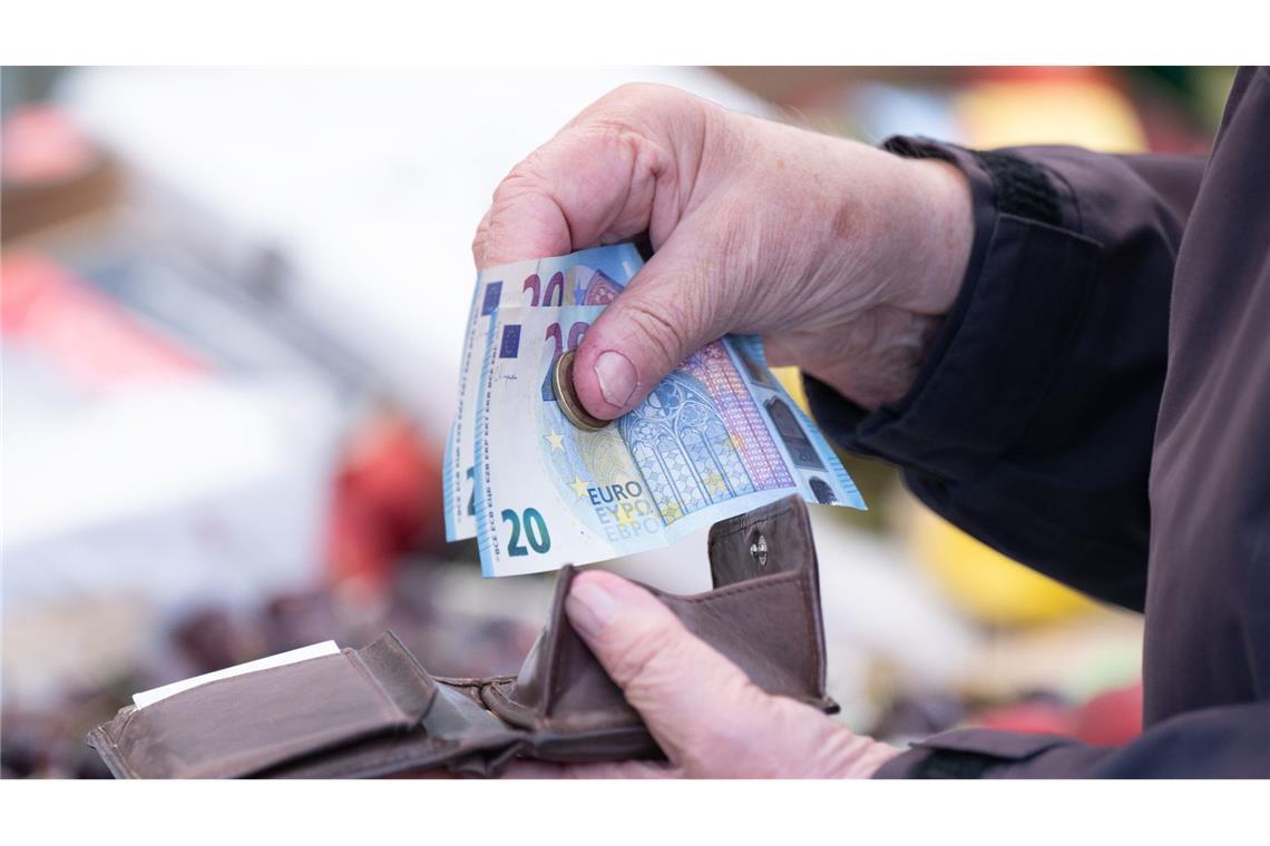 Eine Person sortiert auf einem Wochenmarkt das Wechselgeld für ihre Einkäufe in ein Portemonnaie.(Symbolfoto)