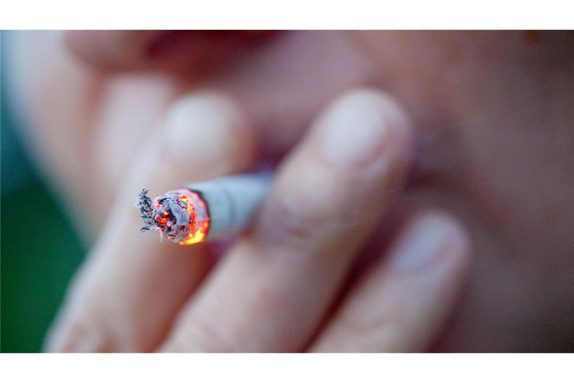 Eine Person zieht an einer Zigarette.