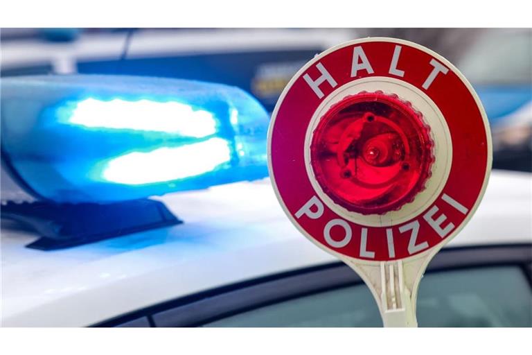 Eine Polizeikelle auf einem Parkplatz an einer Autobahn. Mit einer geladenen Schusswaffe, Amphetamin und Marihuana ist ein 44-Jähriger auf der A9 bei Münchberg (Landkreis Hof) unterwegs gewesen (Symbolfoto).