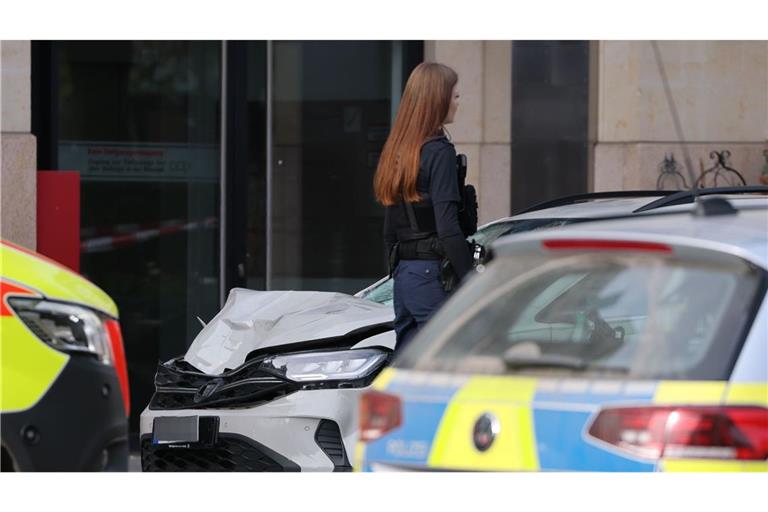 Eine Polizistin steht an der Stelle, wo ein Auto in eine Menschengruppe gefahren ist.