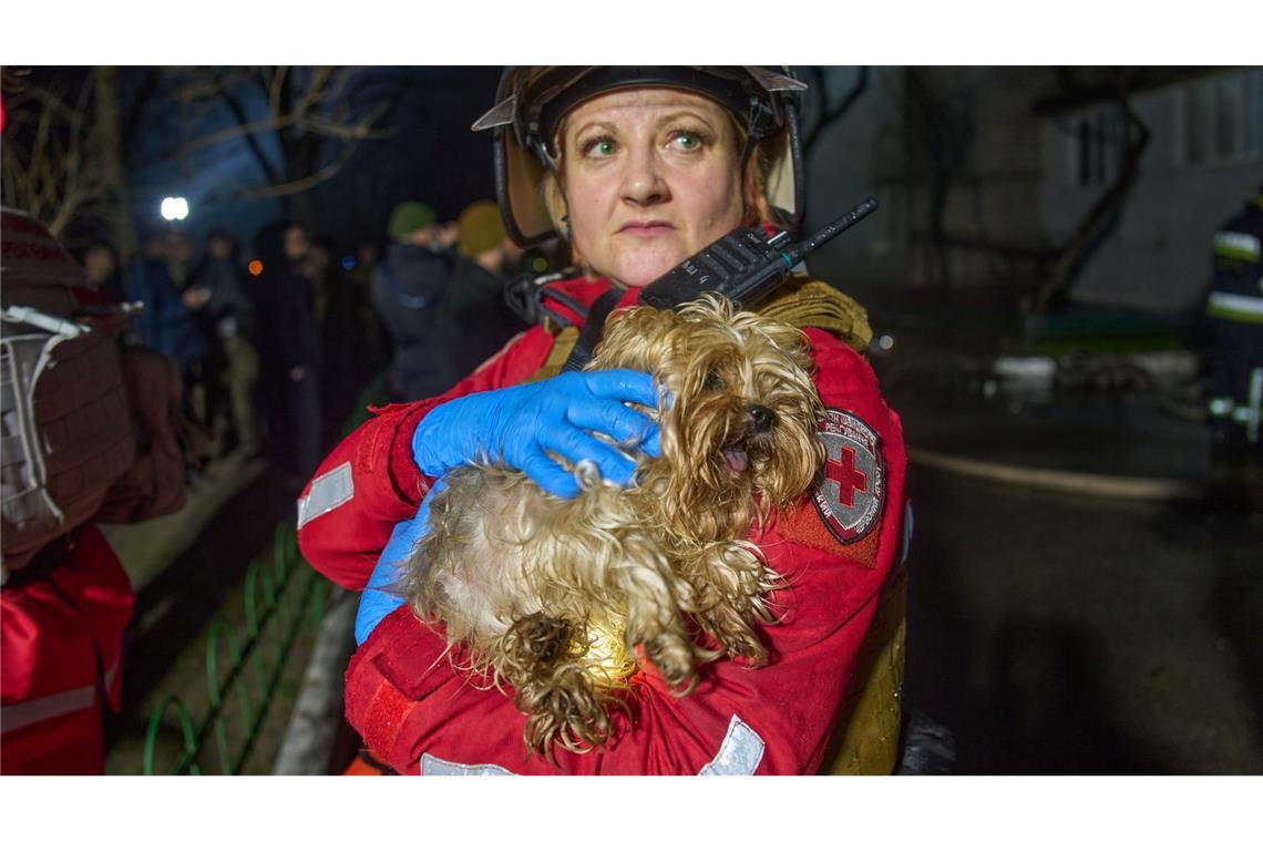 Eine Retterin hält einen geretteten Hund nach dem Einschlag einer russischen Rakete in ein mehrstöckiges Wohnhaus außerhalb von Kiew.