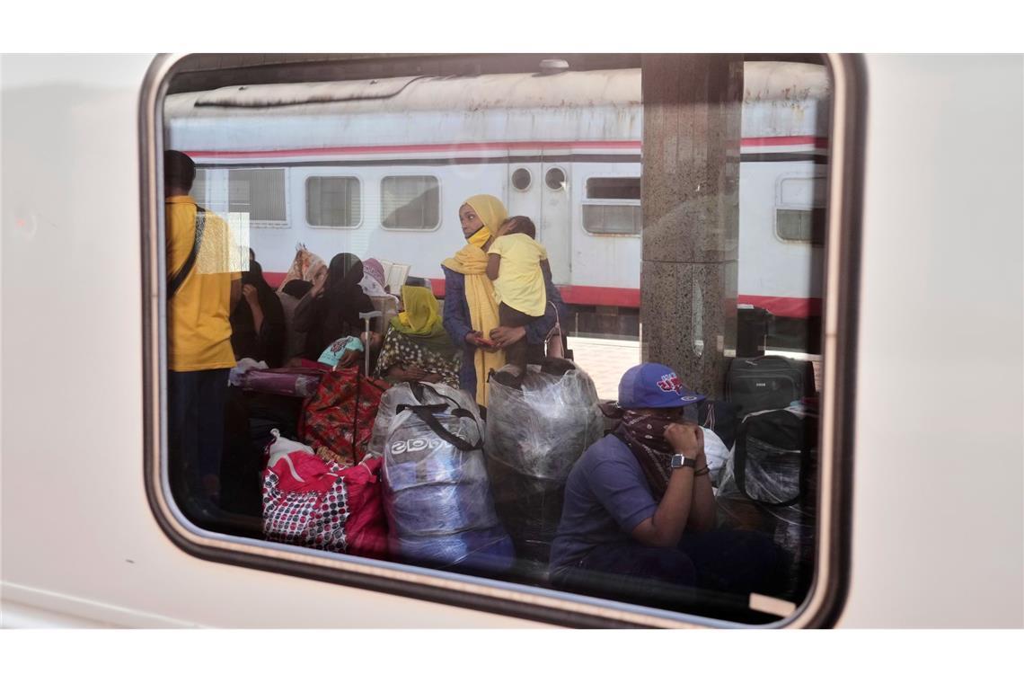 Eine sudanesische Frau und Kinder, die aus ihrer Heimat vertrieben wurden und nun zurückkehren, warten im Kairoer Bahnhof Ramses auf ihren Zug nach Assuan, Ägypten.