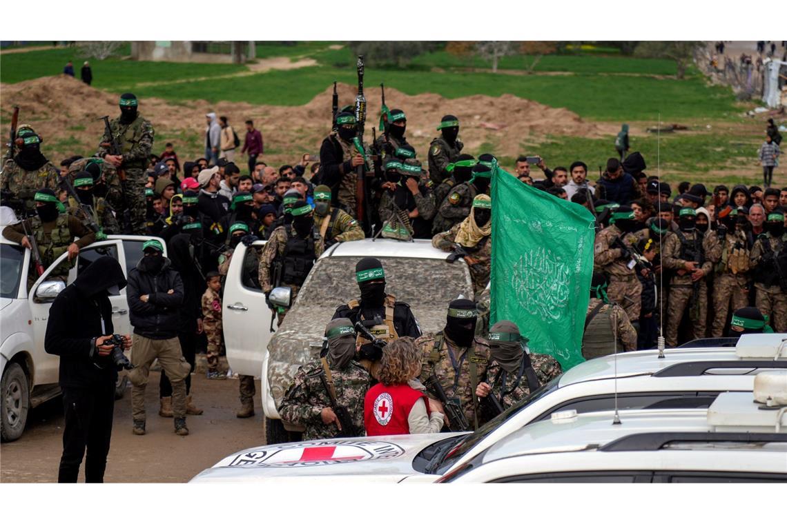 Hamas lässt sechs weitere israelische Geiseln frei Eine Vertreterin des Roten Kreuzes spricht mit Hamas-Mitgliedern.