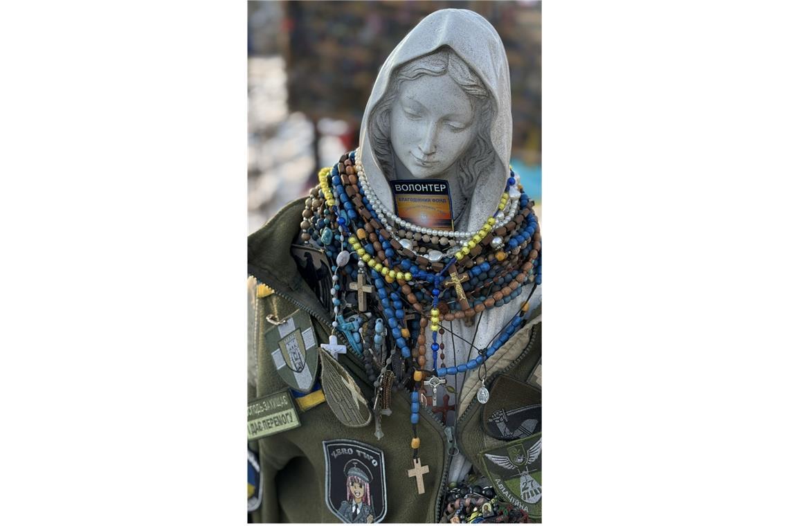 Kaffee, Tee und Wut auf Trump Einer schon immer an dieser Stelle stehenden Marienstatue haben ukrainische Soldaten die Jacke eines toten Kameraden umgehängt. Der Gottesmutter haben sie Rosenkränze um den Hals gehängt.