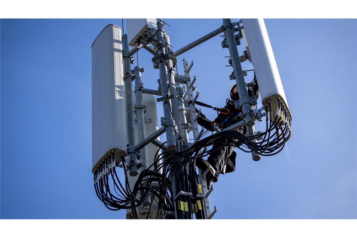 O2 und die Telekom gewinnen Hunderttausende Handykunden Einer von Zehntausenden Mobilfunk-Masten in Deutschland - hier einer, an dem gerade ein Techniker arbeitet.
