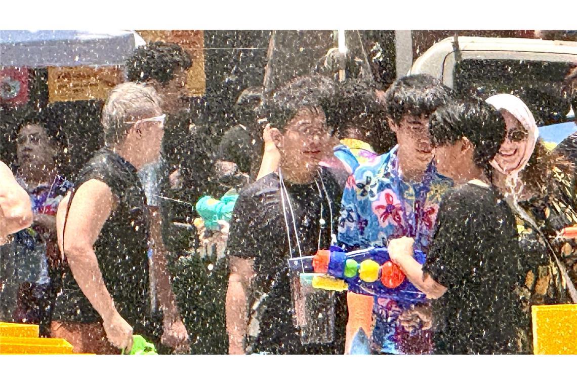 Einheimische und Touristen feiern traditionell zusammen - die meisten sind nach wenigen Minuten klatschnass.