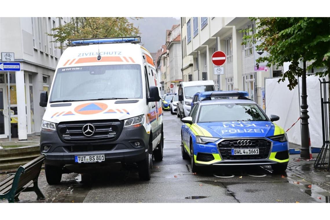 Einsatzfahrzeuge der Polizei stehen vor einem abgesperrten Bereich zu einem Schusswechsel nahe dem Rathaus.