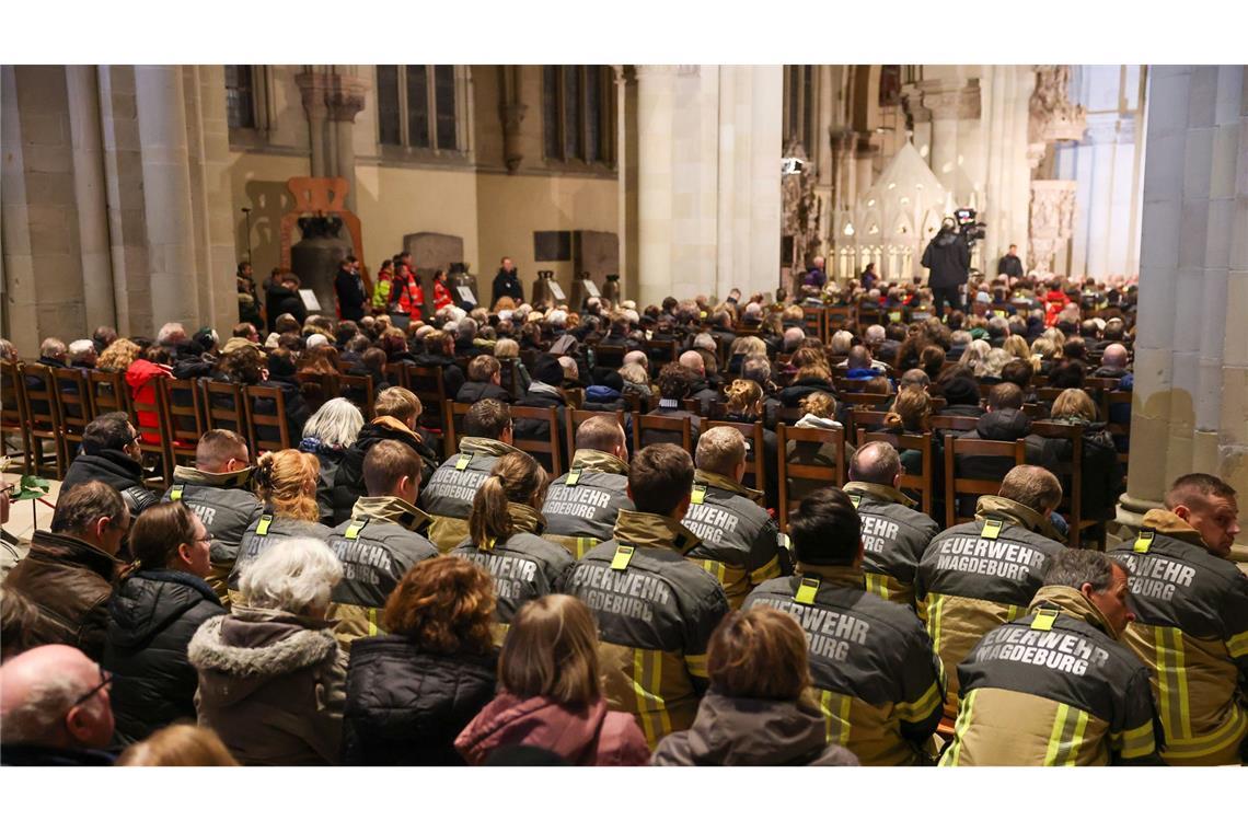 Viele Menschen beteiligen sich an Gedenken in Magdeburg Einsatzkräfte der Feuerwehr sitzen in der Gedenkveranstaltung im Magdeburger Dom.