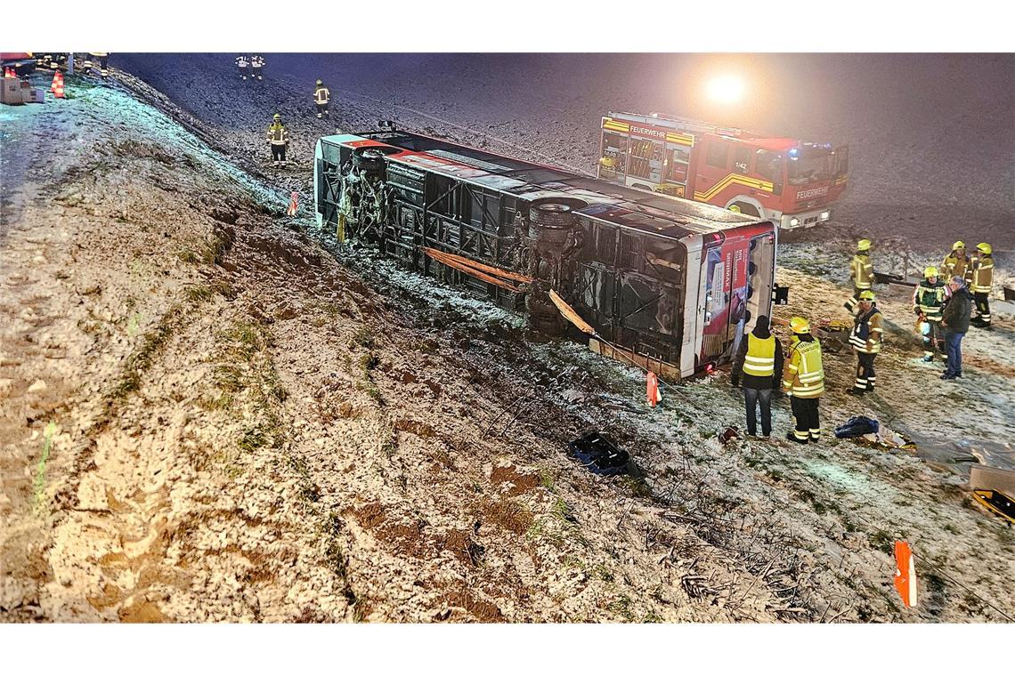Bilder des Tages Einsatzkräfte der Feuerwehr stehen neben einem umgekippten Linienbus an der Unfallstelle im Landkreis Ludwigsburg.