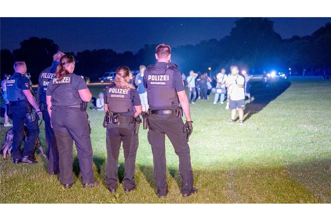 Einsatzkräfte der Polizei und Jugendliche stehen sich im Hamburger Stadtpark gegenüber.