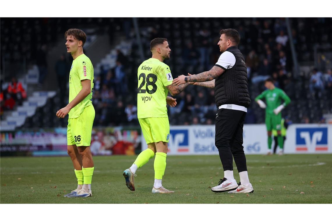 Enttäuschte Kickers-Spieler, SG-Coach Reinhardt tröstet.