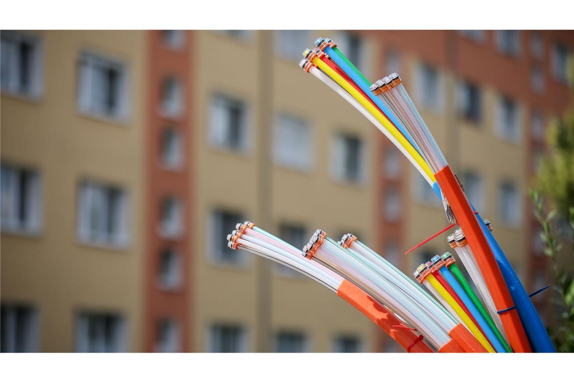 Zehn Millionen Haushalte haben Zugriff auf Telekom-Glasfaser Erst mal angeschlossen, bieten sie Highspeed-Internet: Glasfaserkabel, die aus dem Sockel eines Schaltschranks herausragen.