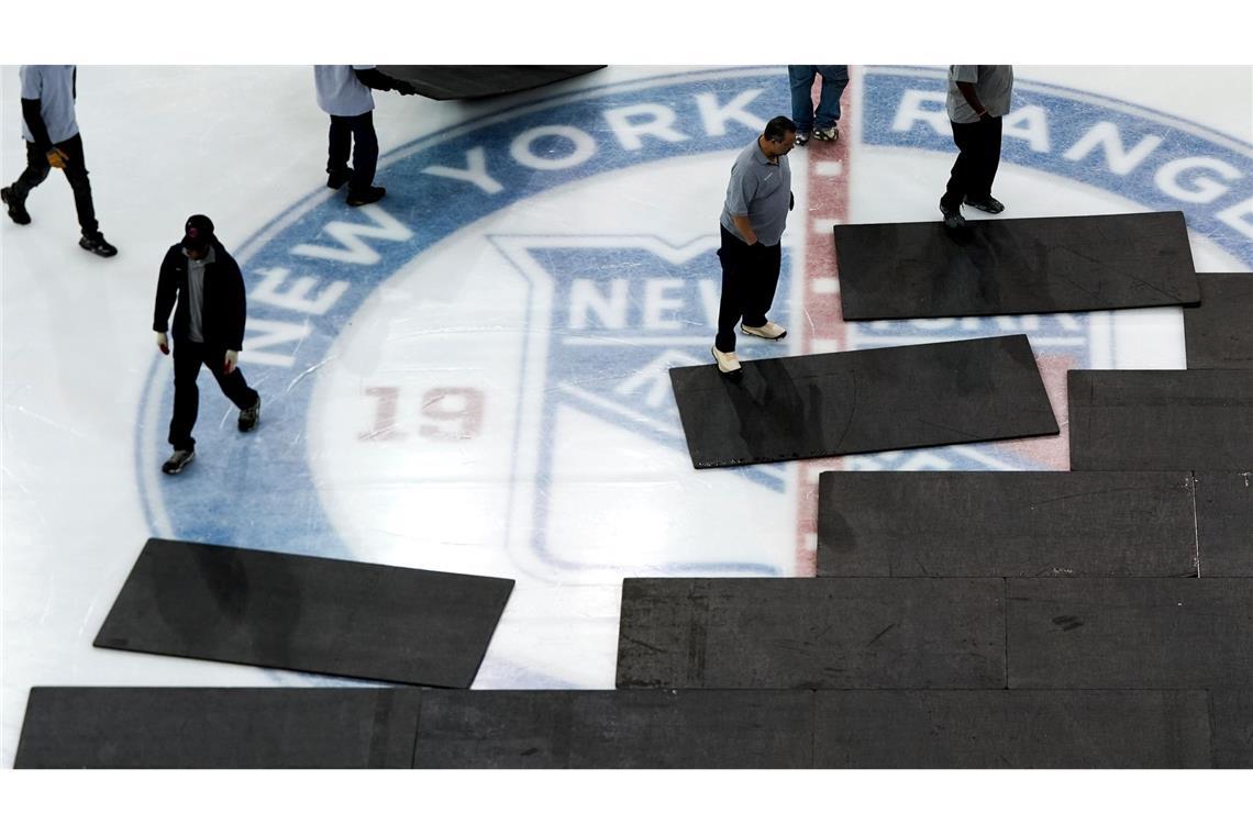 Bilder des Tages Erst NHL Eishockey - danach NBA Basketball im Madison Square Garden. Arbeiter installieren das Basketballfeld über dem Eis.