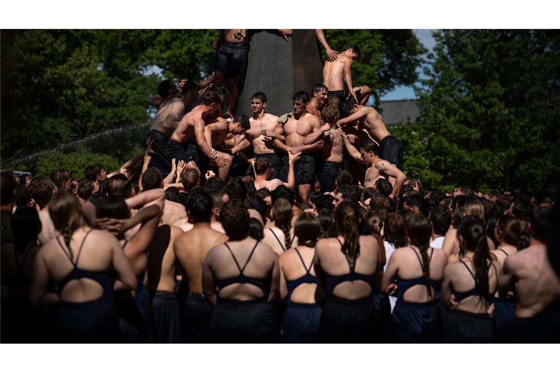 Fähnriche im ersten Jahr erklimmen das Herndon-Denkmal zum Abschluss ihres Studienjahres an der US Naval Academy in Annapolis.