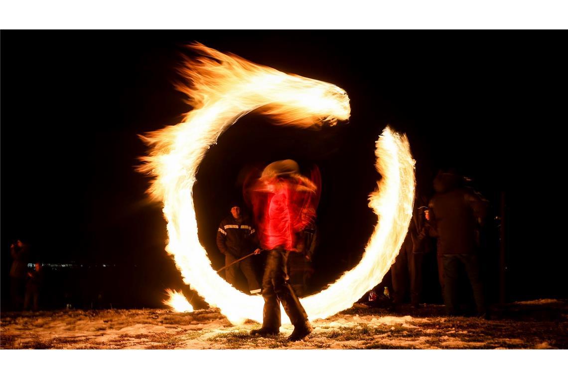 Bilder des Tages Fastnachtstradition in Bulgarien - Ein Bild mit Langzeitbelichtung zeigt einen Jungen, der mit Feuerkugeln spielt, während Ritualen zur Feier von Mesni Zagovezni (Fastnacht) im Dorf Lozen.