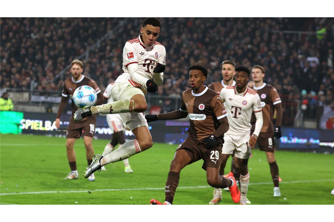 Bilder des Tages FC St. Pauli gegen Bayern München: Münchens Jamal Musiala (2.v.l.) gegen St. Paulis Morgan Guilavogui (M)