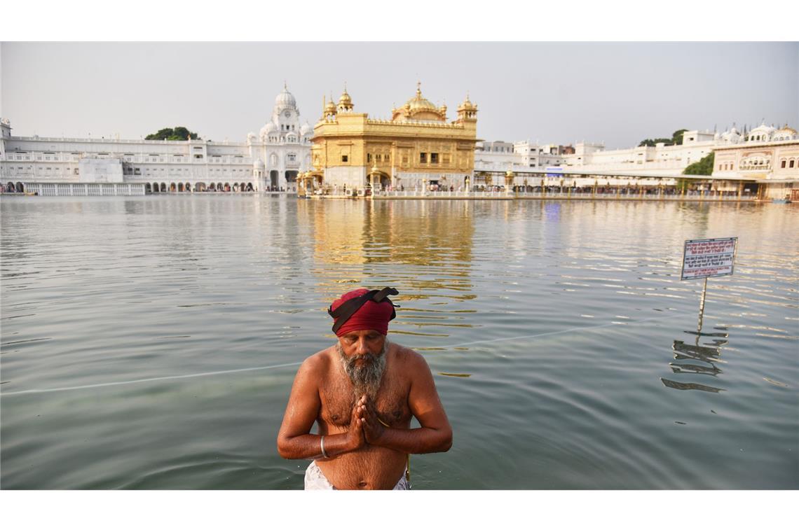 Feiertag Guru Nanak Jayanti: Sikh-Anhänger nimmt ein heiliges Bad im Goldenen Tempel.