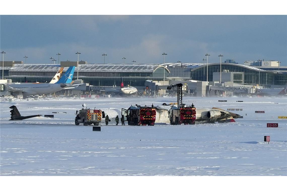 Bilder des Tages Feuerwehrleute des Toronto Pearson International Airport arbeiten an einem auf dem Rücken liegenden Flugzeug der Delta Air Lines.