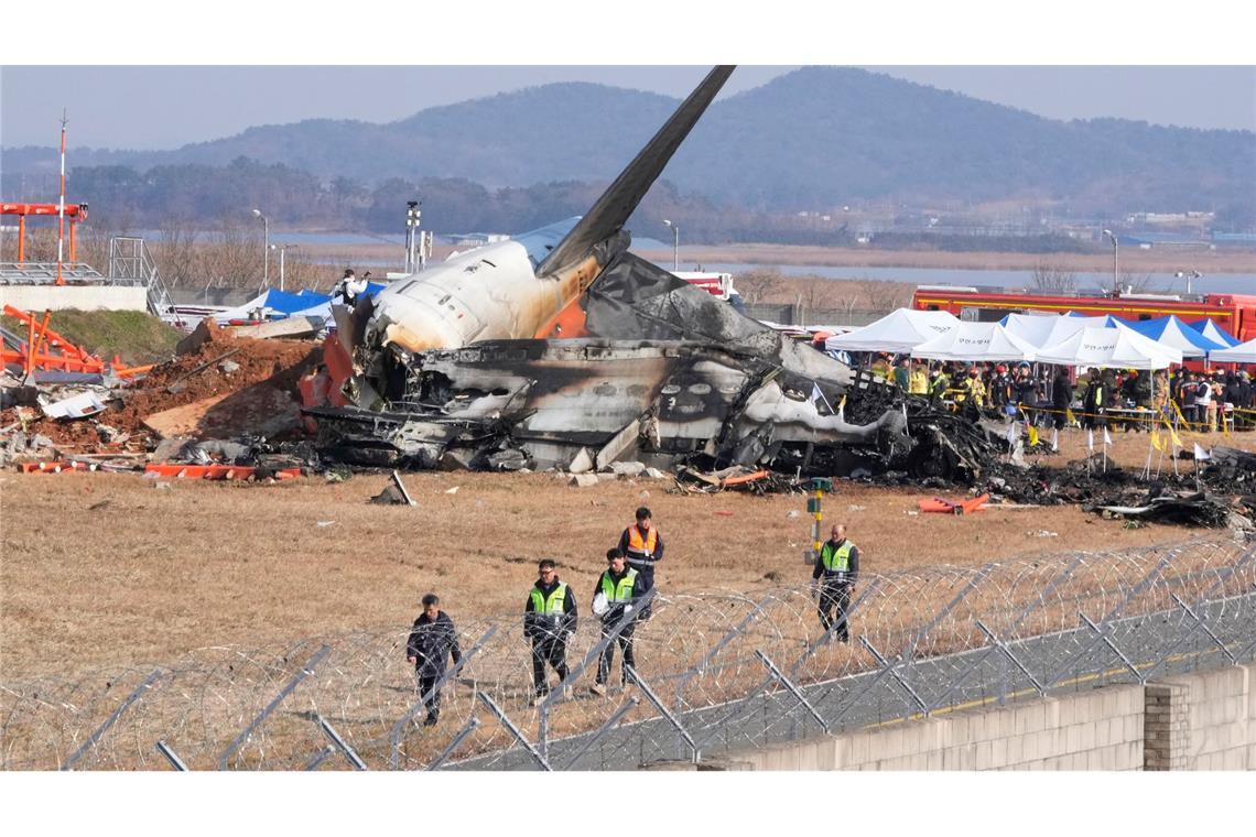 Flugzeug in Südkorea zerschellt - 179 Tote Feuerwehrleute und Rettungskräfte bergen die Opfer des verunglückten Flugzeugs auf dem internationalen Flughafen von Muan.