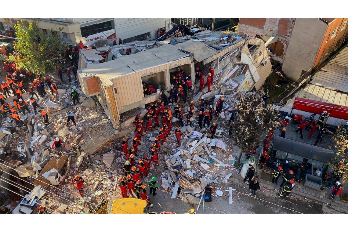 Feuerwehrleute und Rettungskräfte suchen nach dem Einsturz eines Wohngebäudes nach Verschütteten.