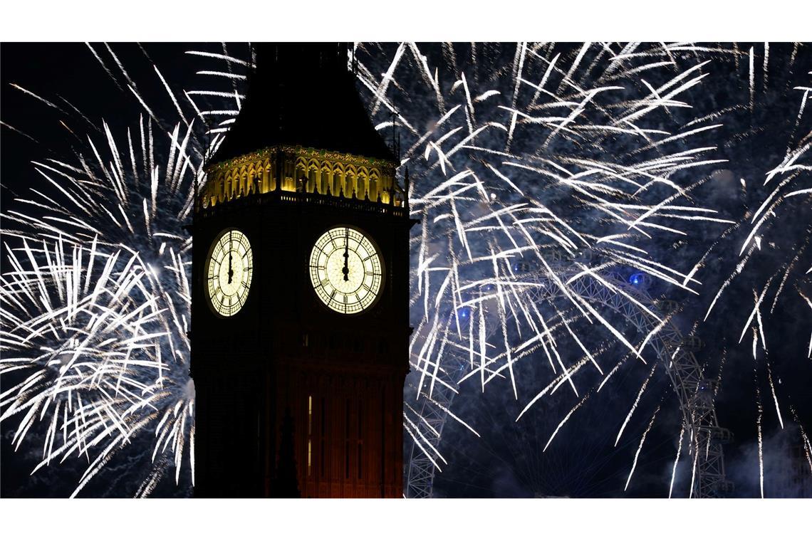 Feuerwerk erhellt den Himmel über dem Elizabeth Tower und dem London Eye im Zentrum Londons während der Neujahrsfeierlichkeiten.