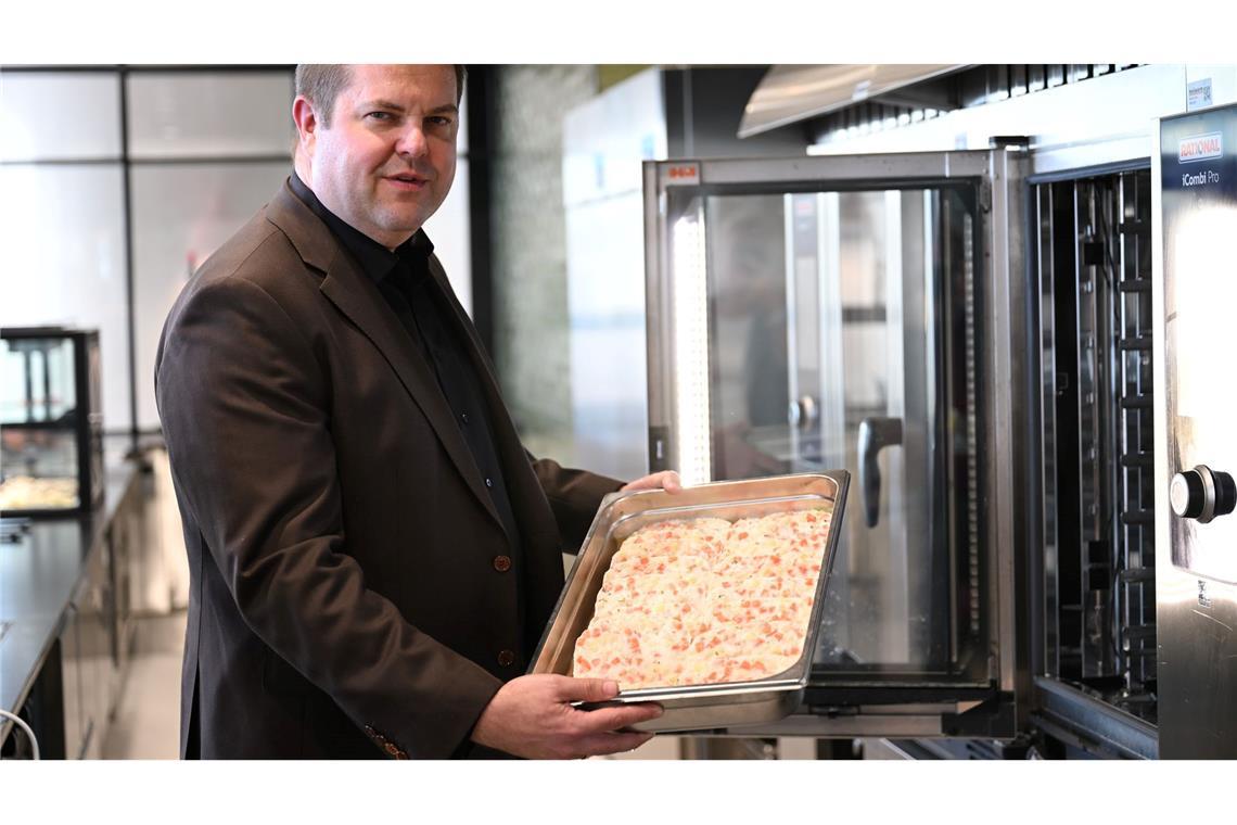 Firmenchef Jan-Peer Laabs hält im Betriebsrestaurant der Apetito-Zentrale eine Schale mit Lachs-Auflauf in der Hand.