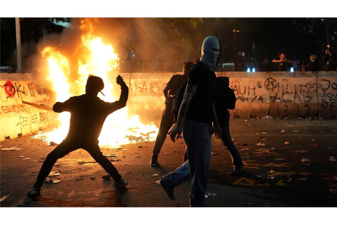 Bilder des Tages Flammender Protest: Demonstranten bewerfen die Polizei mit Steinen bei einer Kundgebung gegen die aktuelle Haushaltspolitik von Präsident Prabowo in Indonesien.