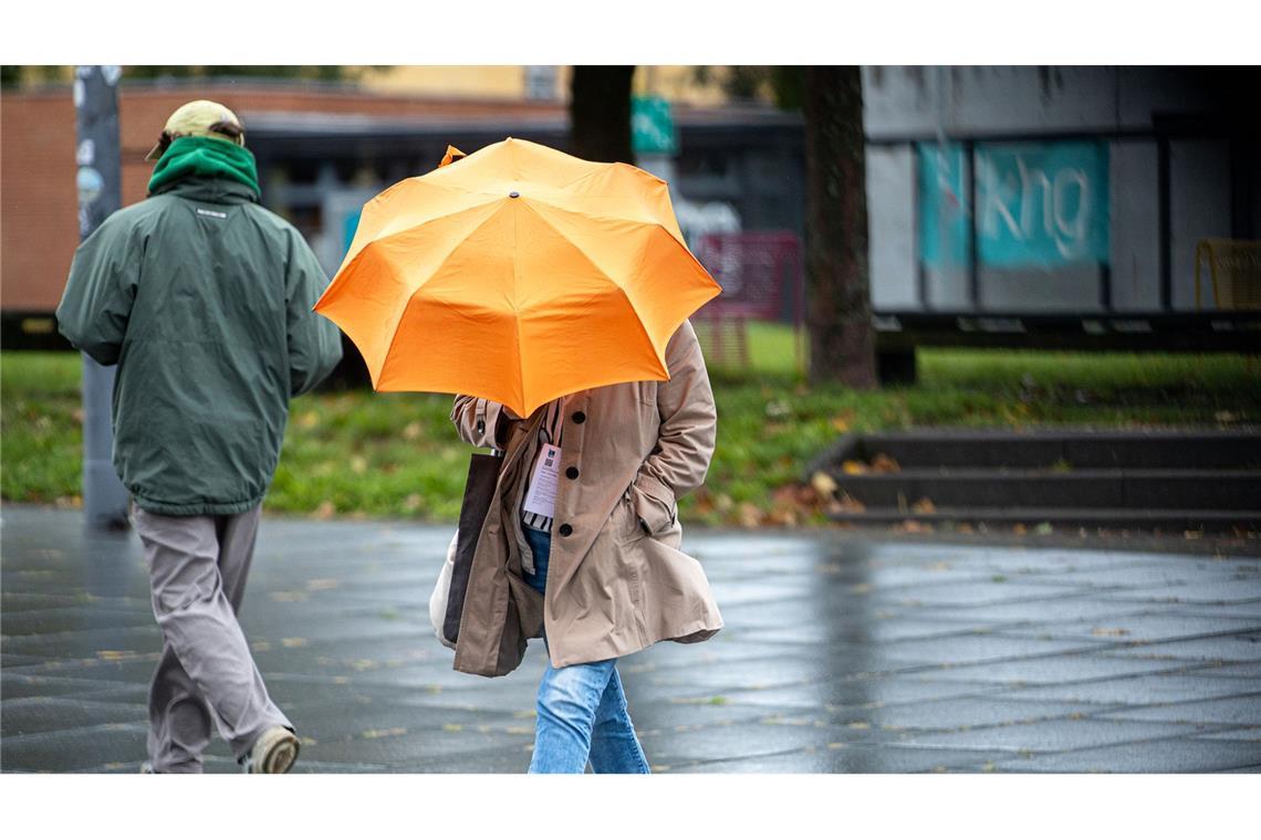 Überschwemmungsgefahr in Baden-Württemberg? Frau mit Regenschirm in Südwestdeutschland.