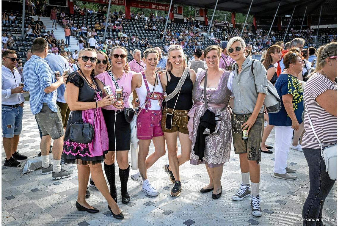 Frauen in Dirndl und Lederhosen freuen sich auf das Konzert, bei dem der Spaßfak...