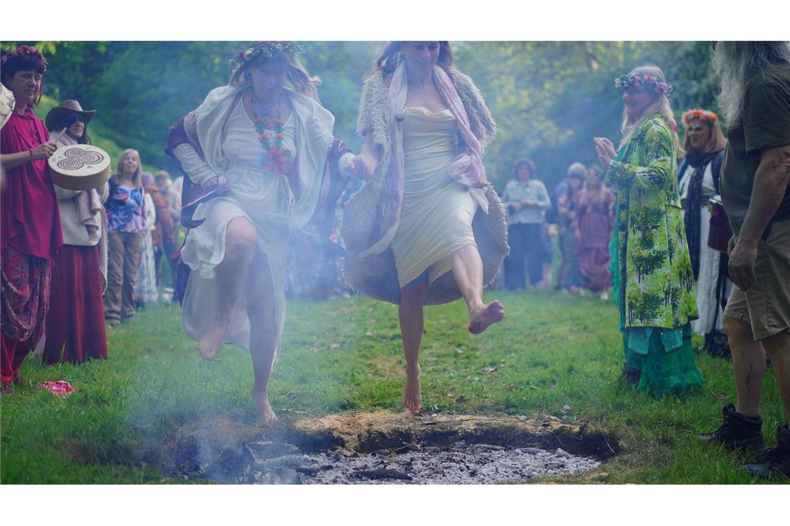 Bilder des Tages Frauen springen beim Beltane-Festival am Glastonbury Chalice Well in England über das Feuer.