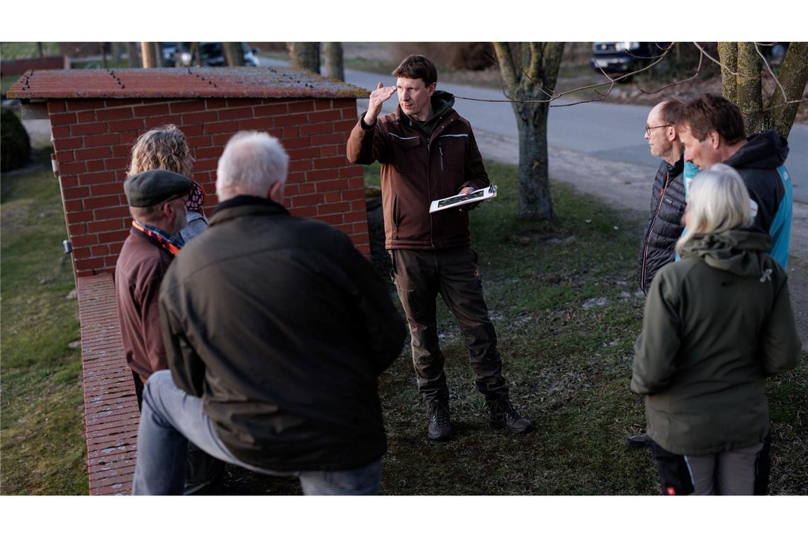 Freiwillige laufen entlang der Felder und zählen die Hähne, die den Revierruf des männlichen Rebhuhnes aus dem Lautsprecher erwidern. Umweltwissenschaftler Marcel Holy (M) erklärt den Ablauf der Kartierung,.