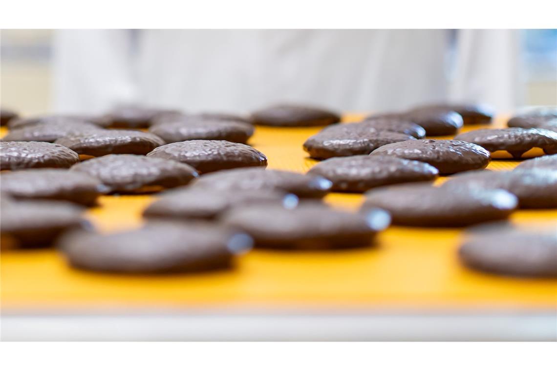 Frisch gebackene Lebkuchen laufen auf einem Band in der Produktion des Lebkuchenherstellers Schmidt.