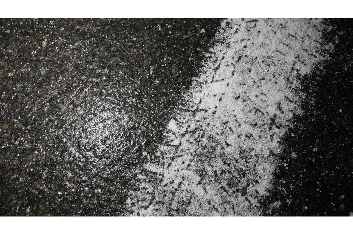 Frische Reifenspuren eines Winterreifens auf spiegelglatter Straße zeigen die winterlichen Straßenverhältnisse im Harz.