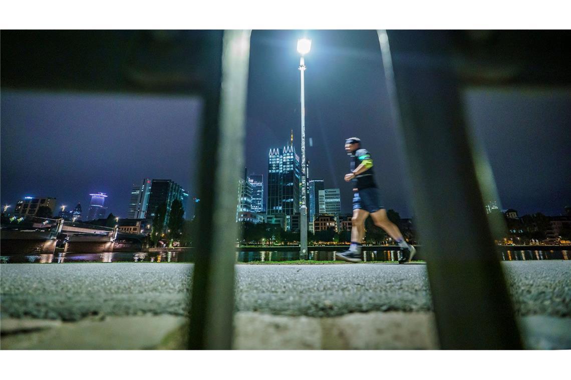 Bilder des Tages Frühsport in der Banken-Stadt: Ein Jogger läuft am frühen Morgen vor der Skyline von Frankfurt am Main.