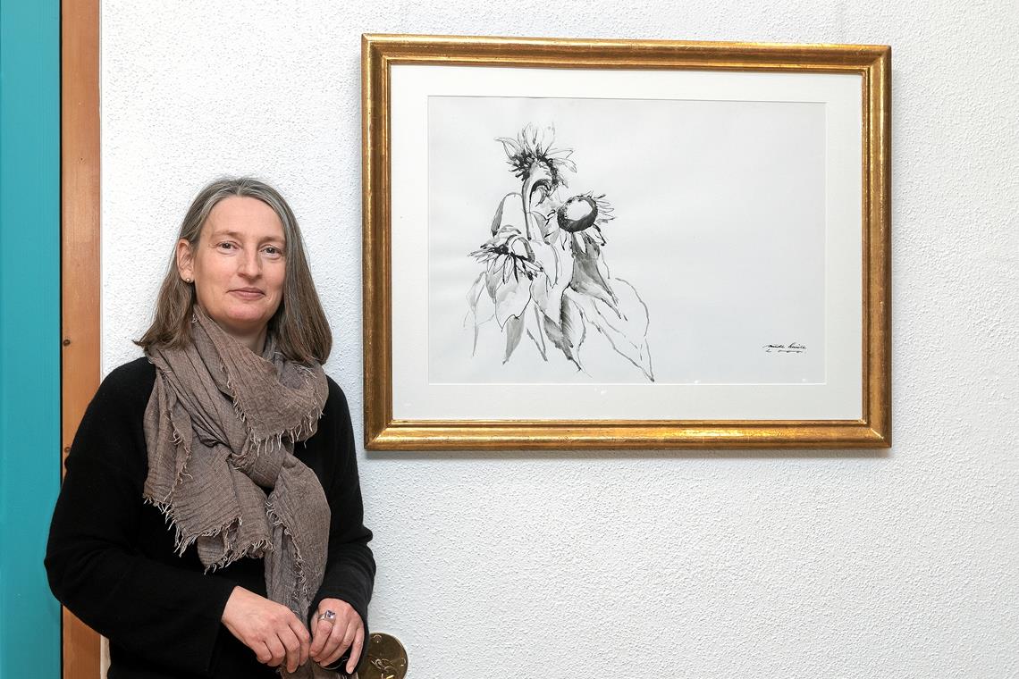 Gabriele Rösch vor dem Bild von Trude Schüle, das ein Sonnenblumenensemble stil- und liebevoll einfängt. Foto: J. Fiedler