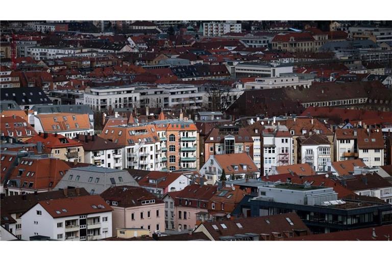 Gebäude werden in der Stuttgarter Innenstadt durch ein Wolkenloch von der Sonne angestrahlt.