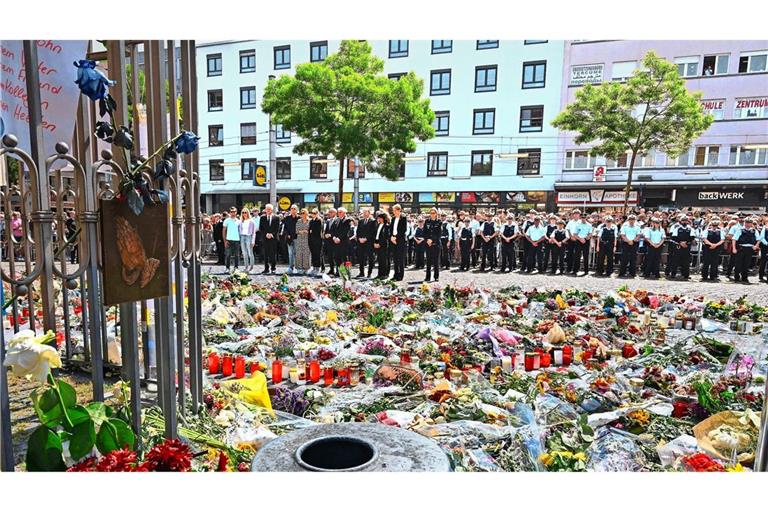 Gedenkfeier für Rouven Laur auf dem Mannheimer Marktplatz. Von den beiden Bäumen, unter denen die Polizisten stehen, lief am Tattag Youssuf Hanash los, um sich dem Attentäter entgegenzustellen und zu helfen.