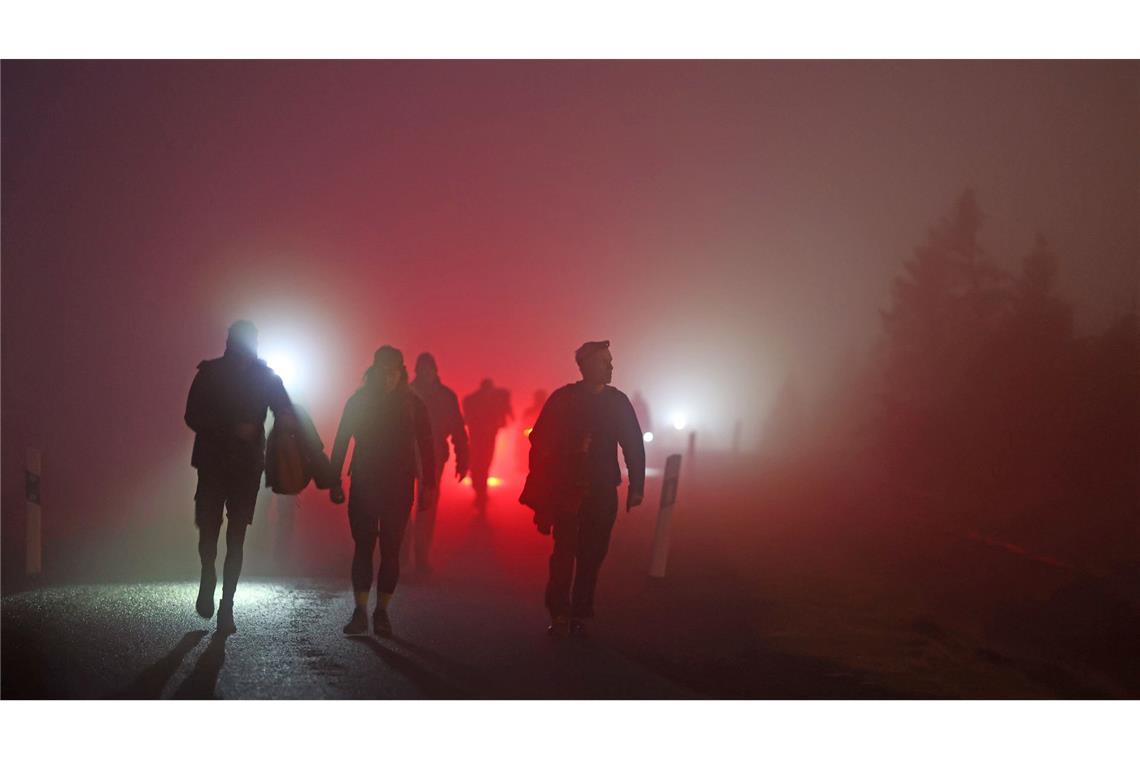 Geocacher kommen vor Sonnenaufgang auf den Brocken im Harz.