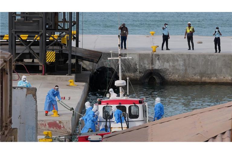 Gesundheitspersonal in Schutzkleidung evakuiert Patienten vom Kreuzfahrtschiff "Hondius" in einem Hafen.