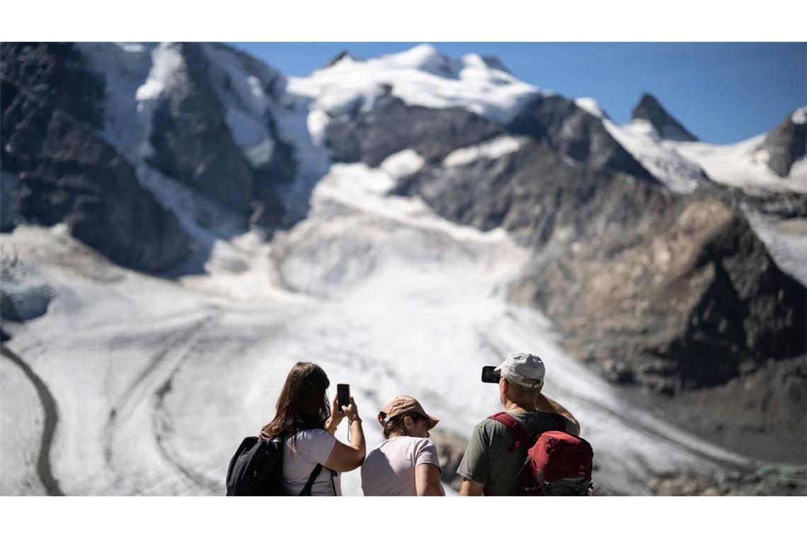 Gletscher in der Schweiz: Was auf den ersten Blick pittoresk wirkt - ein idyllischer Sommertag in den Alpen mit Touristen, die einen Gletscher fotografieren - ist in Wirklichkeit ein Warnsignal. Die Alpengletscher schmelzen immer schneller dahin.