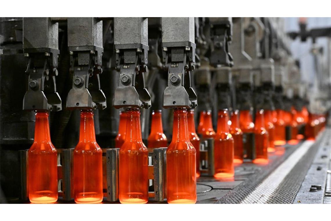 Glühend heiße Glasflaschen kommen aus einer Anlage beim Behälterglashersteller Wiegand-Glas.