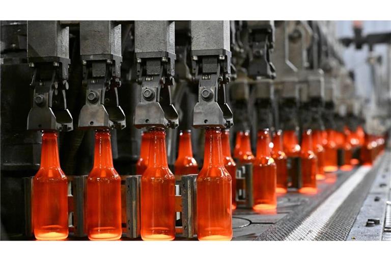 Glühend heiße Glasflaschen kommen aus einer Anlage beim Behälterglashersteller Wiegand-Glas.