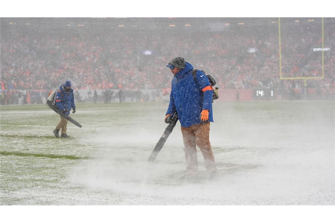 Greenkeeper der Denver Broncos blasen den Schnee von den Yard-Linien.