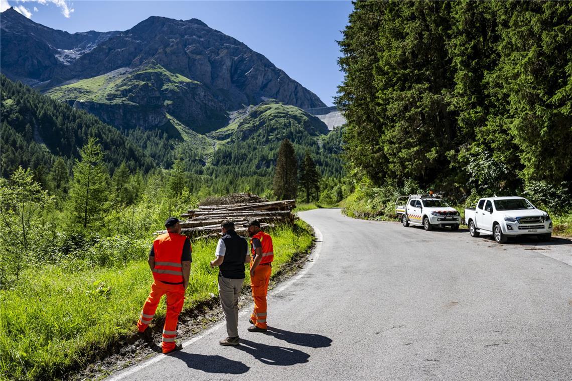 Zugang zu Grande Dixence nach einem Felssturz gesperrt Gregory Logean, Präsident der Gemeinde Heremence, spricht mit Männern auf der gesperrten Straße vor der Staumauer Grande Dixence im Wallis.