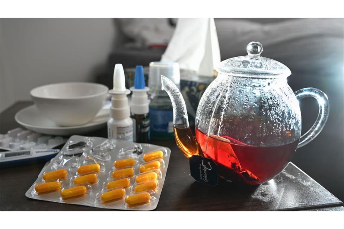 Grippe: ARCHIV - 29.10.2023, Baden-Württemberg, Stuttgart: Medikamente und eine Kanne und Tasse Tee zur Bekämpfung einer Erkältung sind auf einem Nachttisch aufgestellt. (zu dpa: «Erkältung, Grippe und Co: Wie sieht es in Thüringen aus?») Foto: Bernd Weißbrod/dpa +++ dpa-Bildfunk +++