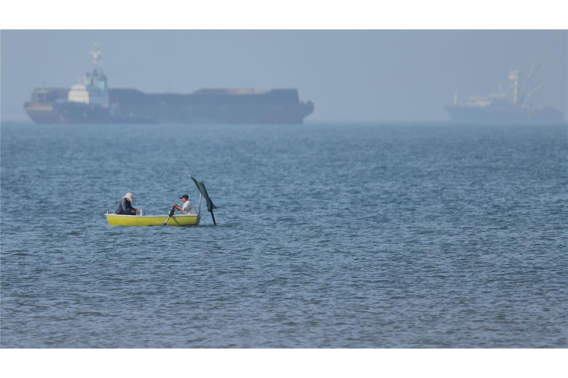 Große Weltlage, kleiner Kahn: Zwei Männer fahren in einem Ruderboot in der Straße von Hormus.