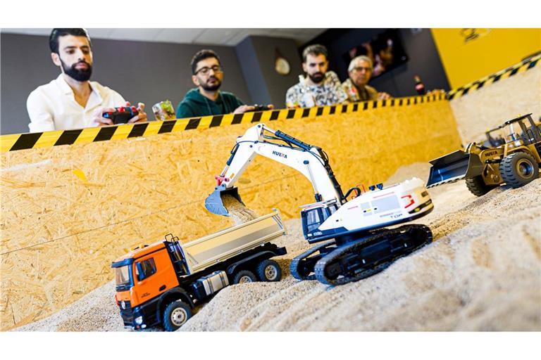 Gründer Siymo Othman (links) steuert mit Freunden kleine Bagger, Radlader und Lastwagen in seinem neu eröffneten Bagger-Café. Es soll das erste dieser Art in Deutschland sein.